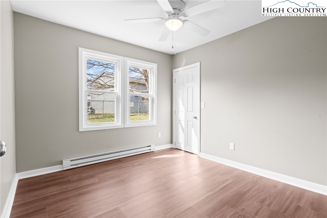 2015 Highway 194 Boone, NC 28607 - Photo 13 of 40 an empty room with wooden floor chandelier fan and windows