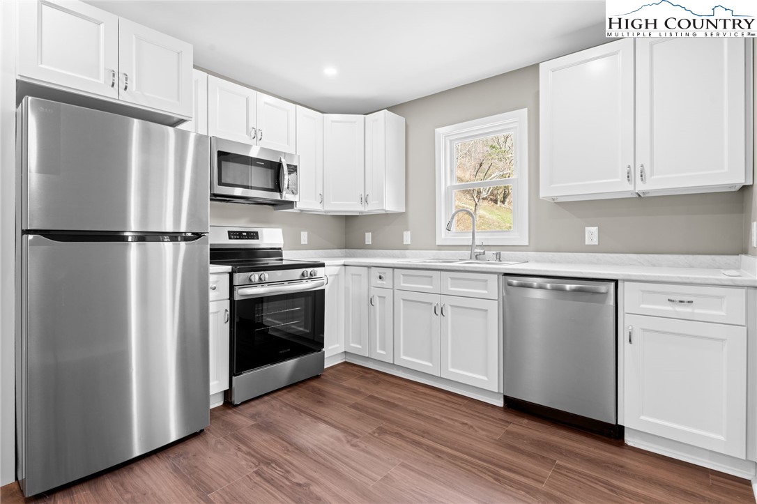 2015 Highway 194 Boone, NC 28607 - Photo 3 of 40 a kitchen with white cabinets white stainless steel appliances and wooden floors