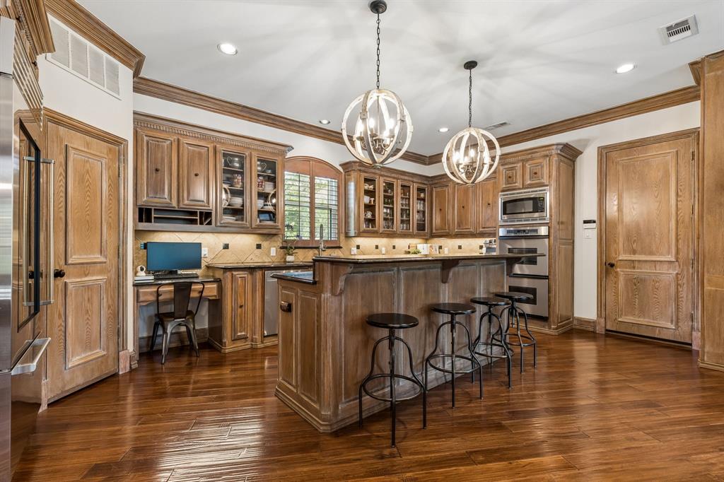 310 Deer Path Fairview, TX 75069 - Photo 12 of 40 a view of a dining room kitchen island wooden floor and stainless steel appliances