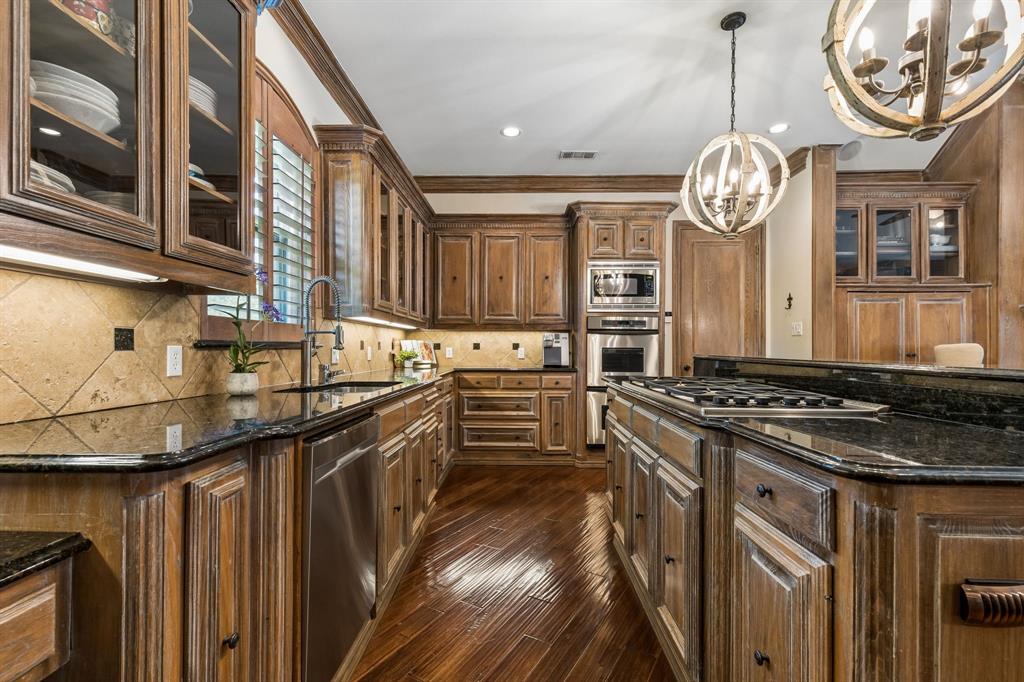 310 Deer Path Fairview, TX 75069 - Photo 10 of 40 a kitchen with stainless steel appliances granite countertop a stove and a sink