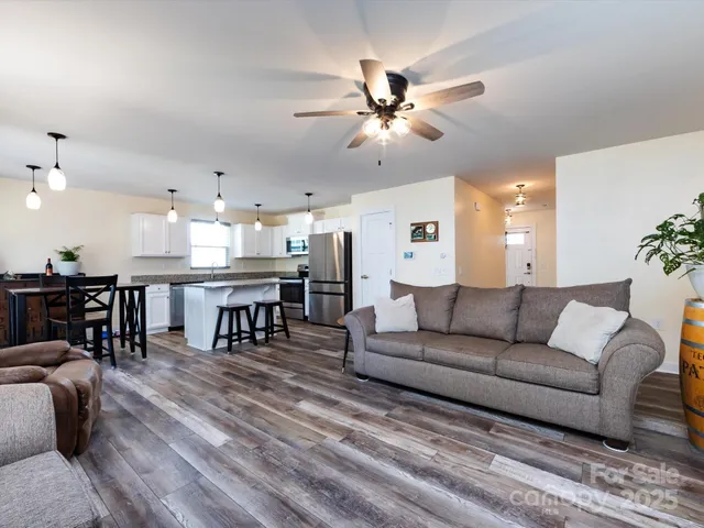 a living room with furniture and kitchen view