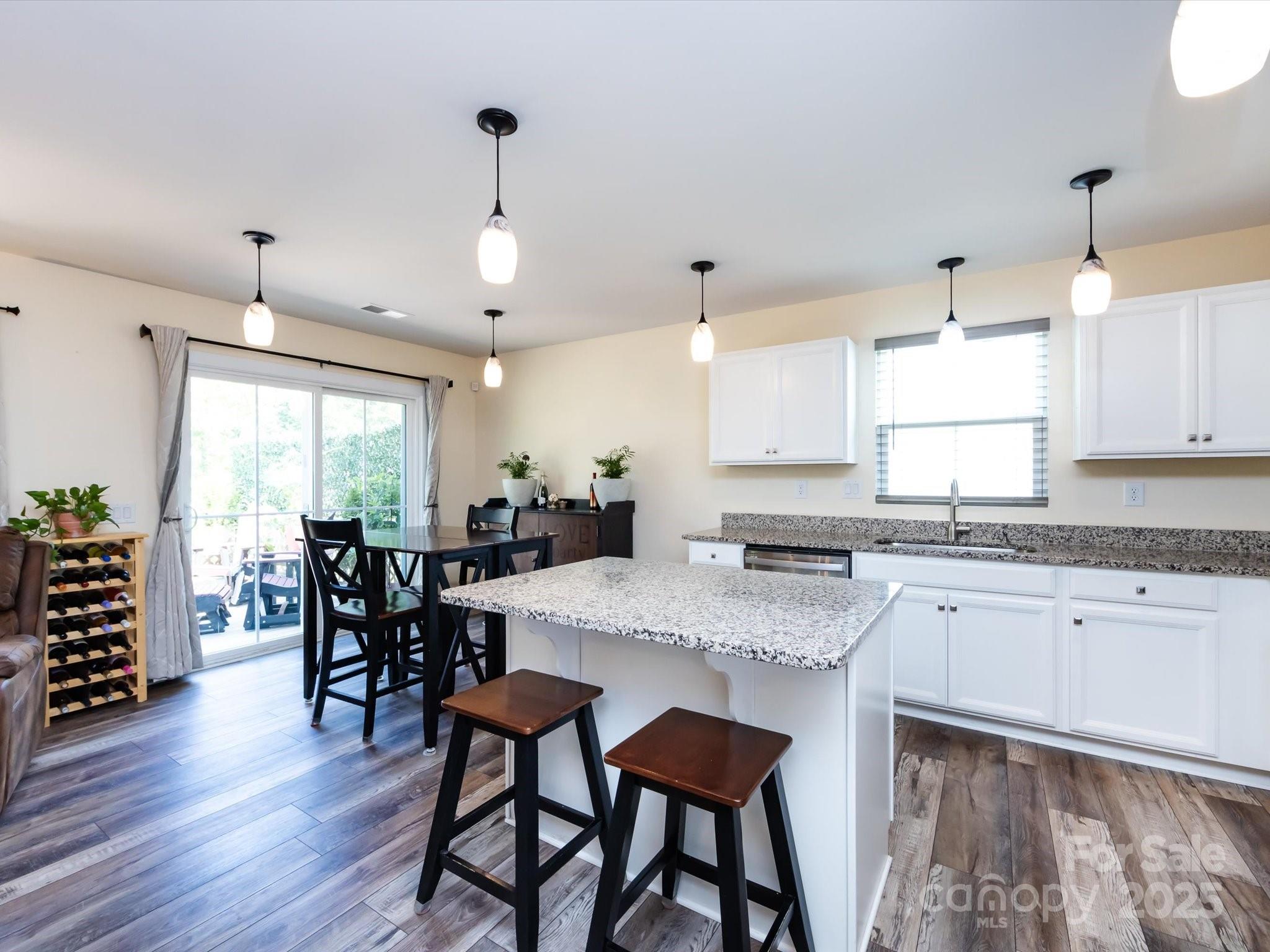 4499 Hunton Dale Road Northwest Concord, NC 28027 - Photo 15 of 43 a kitchen with stainless steel appliances granite countertop wooden floor dining table and chairs