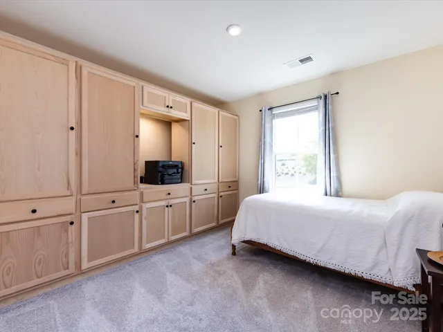 a bed sitting in a bedroom next to a window