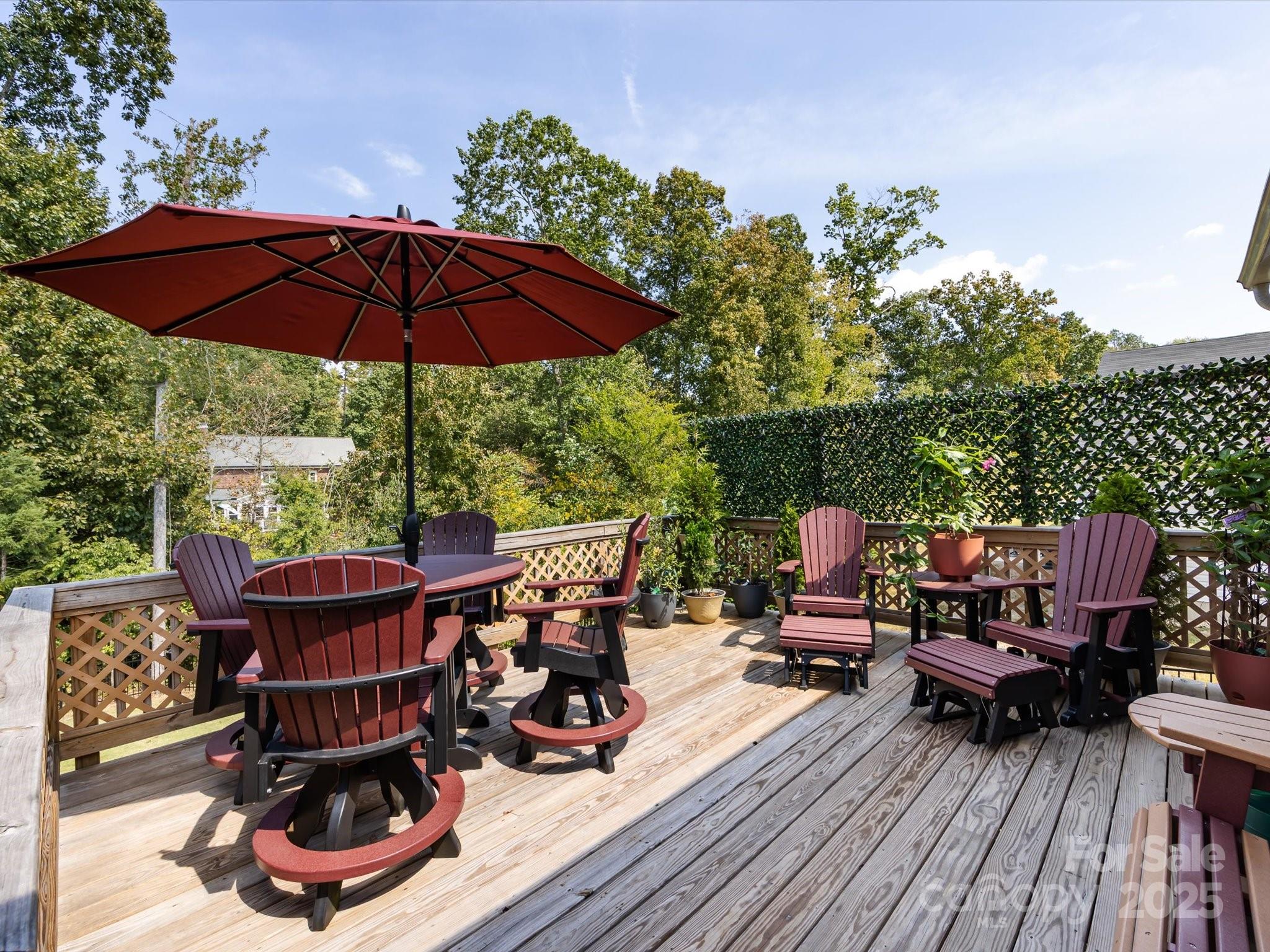 4499 Hunton Dale Road Northwest Concord, NC 28027 - Photo 41 of 43 a view of a roof deck with table and chairs under an umbrella with wooden floor