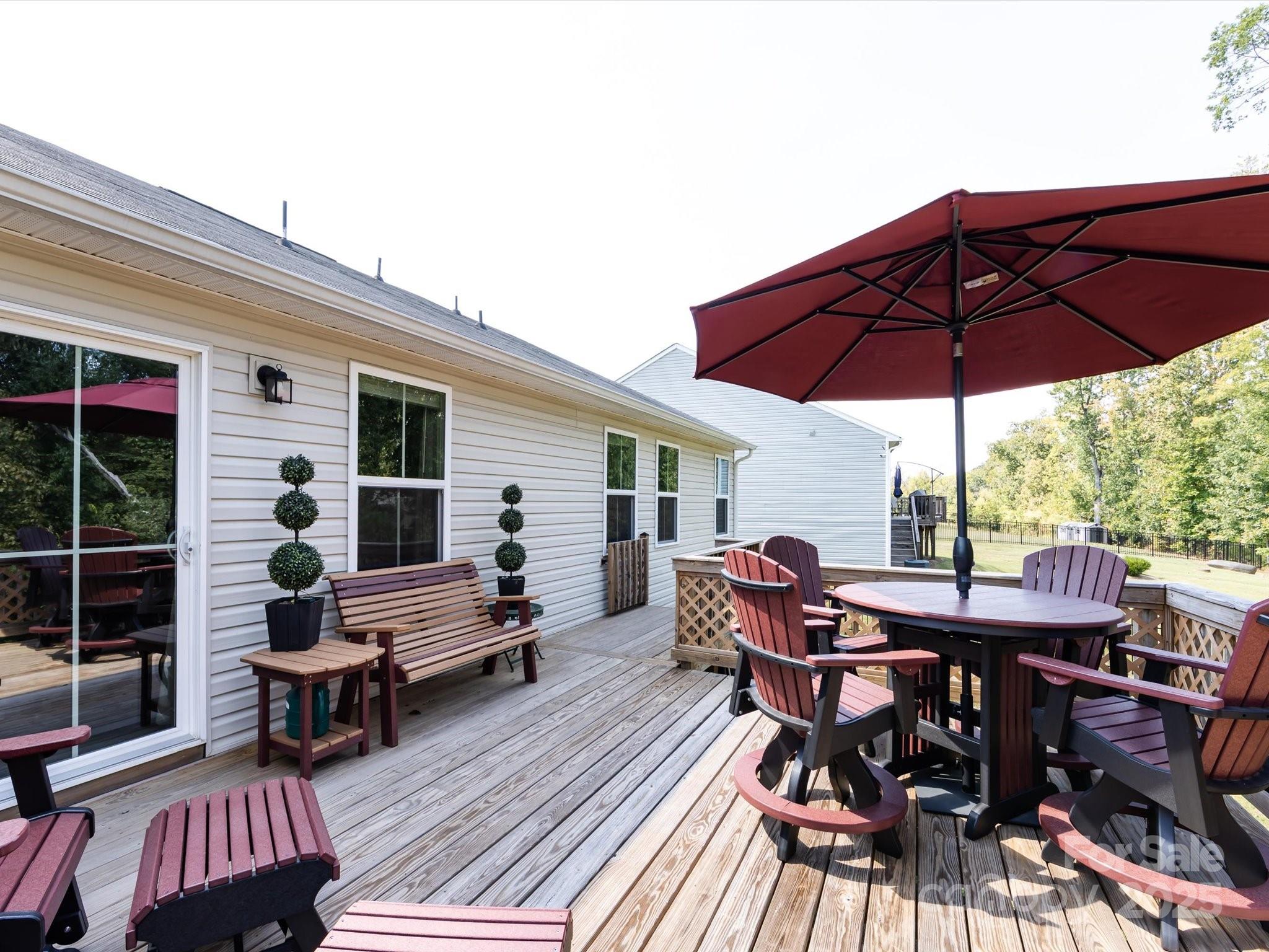 4499 Hunton Dale Road Northwest Concord, NC 28027 - Photo 43 of 43 a patio with wooden floor a yard a table and chairs
