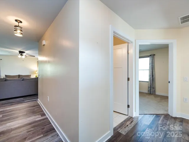 a view of a hallway with wooden floor and staircase