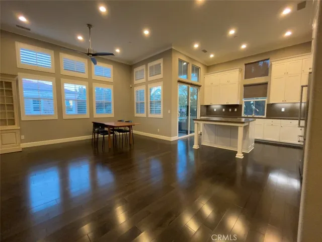 a open kitchen with stainless steel appliances granite countertop a stove and a large refrigerator with wooden floor