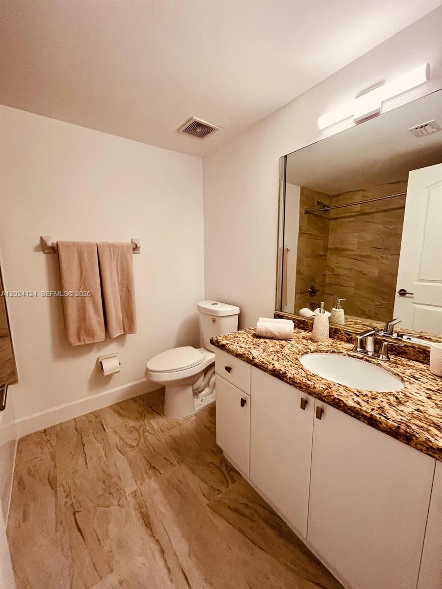 120 South Douglas Road, Unit 302 Miami, FL 33134 - Photo 17 of 28 a bathroom with a granite countertop sink and a large mirror