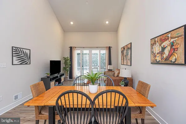 a view of a dining room with furniture a chandelier and wooden floor