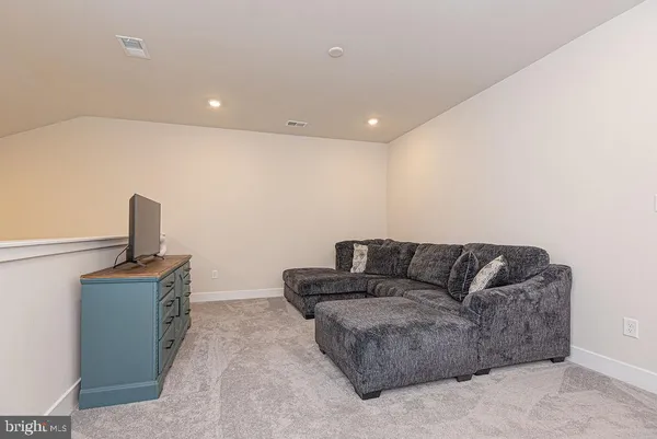 a living room with furniture and a painting on the wall