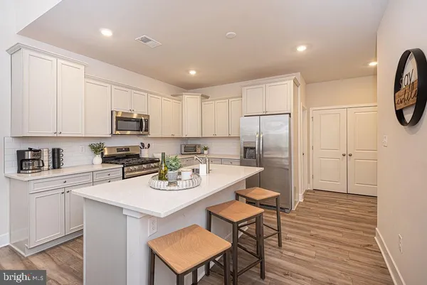 a kitchen with white cabinets stainless steel appliances and sink