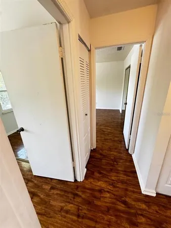 a view of a hallway with wooden floor and staircase