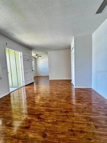 a view of empty room with wooden floor
