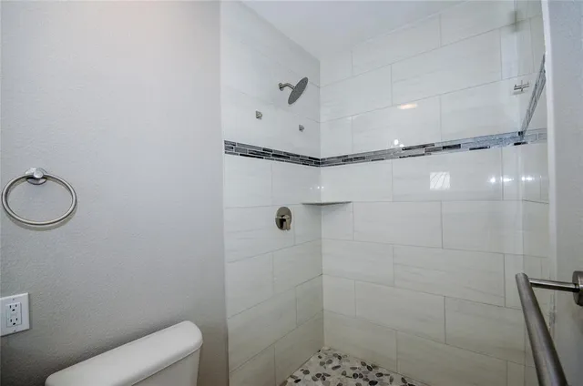 a bathroom with a toilet and a shower