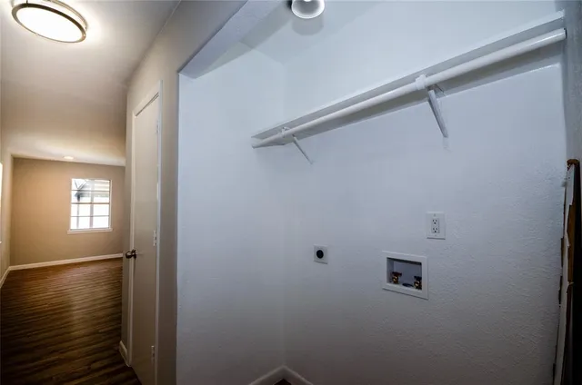 a view of a kitchen with wooden floor and a refrigerator