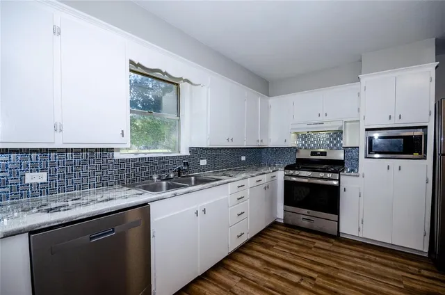 a kitchen with a sink stove and cabinets