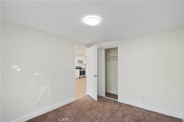 an empty room with closet and mirror