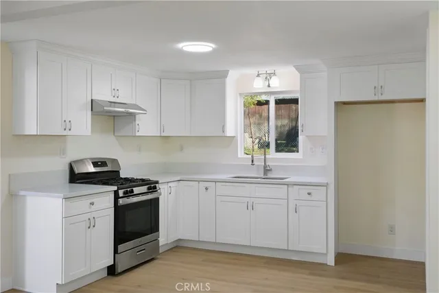 a kitchen with stainless steel appliances a sink stove and cabinets