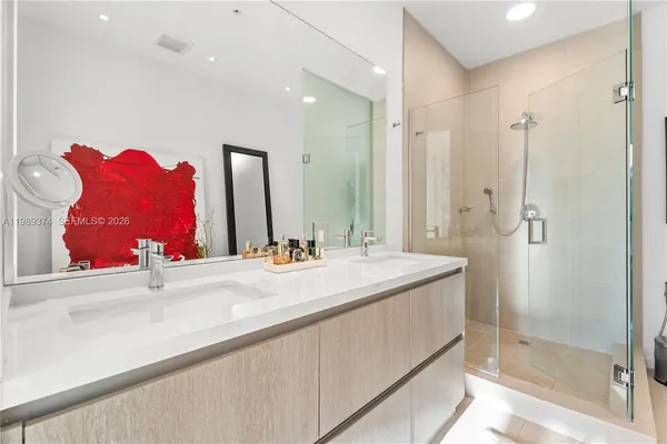 a bathroom with a sink vanity mirror and shower