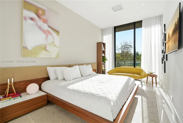 a bedroom with a bed and a large window