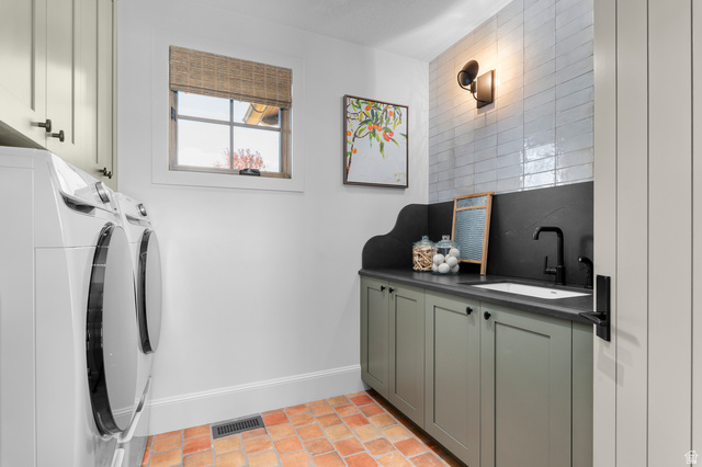 2192 East Outlaw Road Kamas, UT 84036 - Photo 47 of 80 Terracotta tile flooring, built-in cabinetry with matte black hardware, integrated sink with a black gooseneck faucet, and white subway tile backsplash