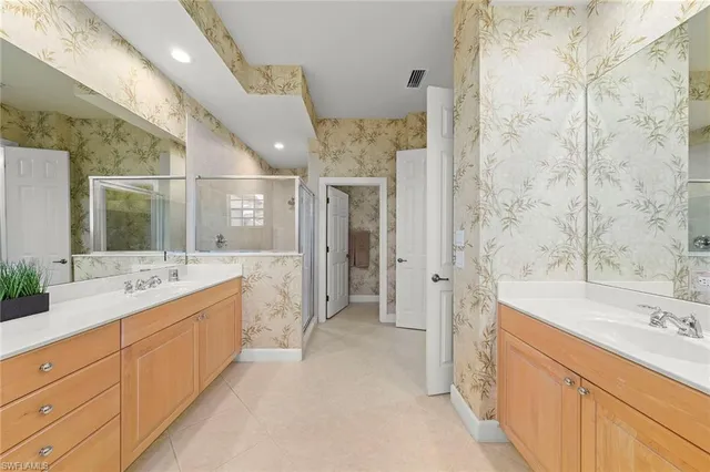 a spacious bathroom with a double vanity sink mirror and shower