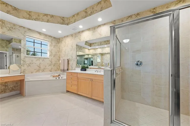 a bathroom with a granite countertop bathtub shower sink vanity and toilet