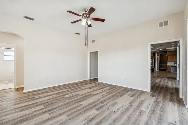 an empty room with a window and a ceiling fan