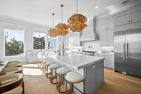 a large kitchen with a stove and a chandelier
