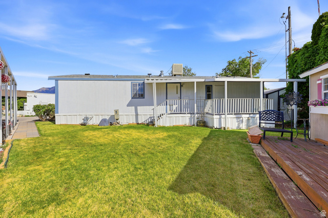 150 West 7500th South, Unit 55 Midvale, UT 84047 - Photo 26 of 28 Expansive backyard featuring a manicured lawn, a raised deck, and a covered porch