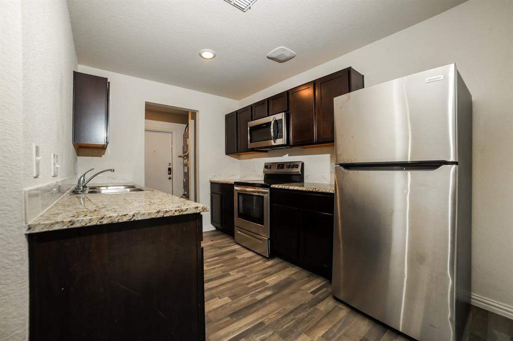903 Olive Street Waco, TX 76704 - Photo 7 of 21 a kitchen with a refrigerator sink and wooden cabinets