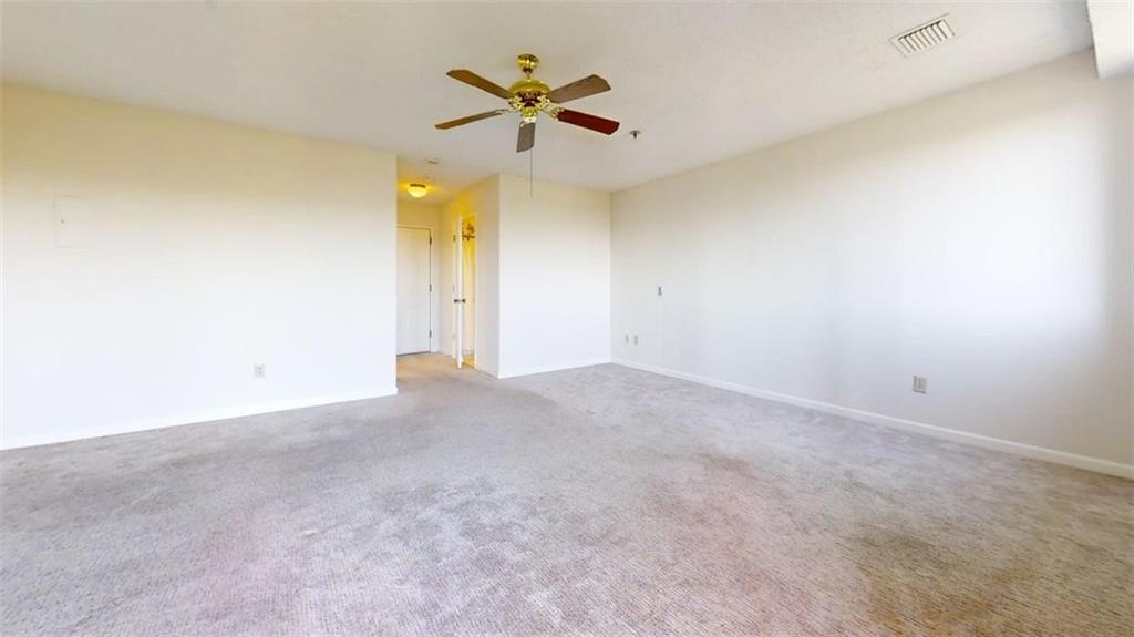 an empty room with a ceiling fan and window