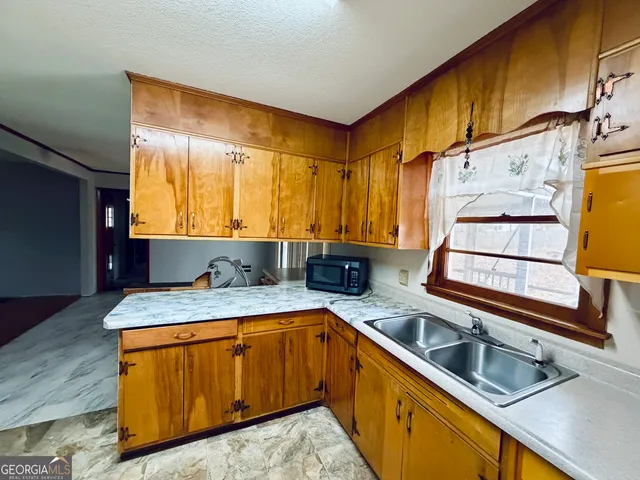 a kitchen with a sink stove and cabinets