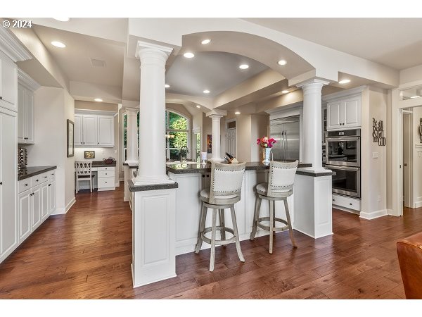 264 Southeast 41st Court Gresham, OR 97080 - Photo 14 of 37 a kitchen with stainless steel appliances kitchen island granite countertop a dining table chairs and white cabinets