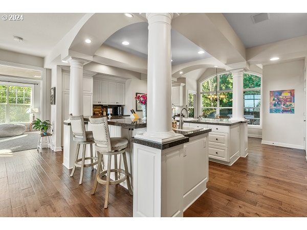 264 Southeast 41st Court Gresham, OR 97080 - Photo 16 of 37 a open kitchen with granite countertop a stove and white cabinets with wooden floor