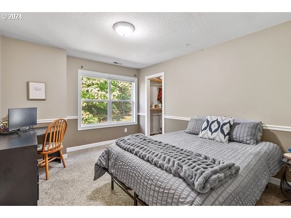 264 Southeast 41st Court Gresham, OR 97080 - Photo 28 of 37 a bedroom with a bed a chair and a large window