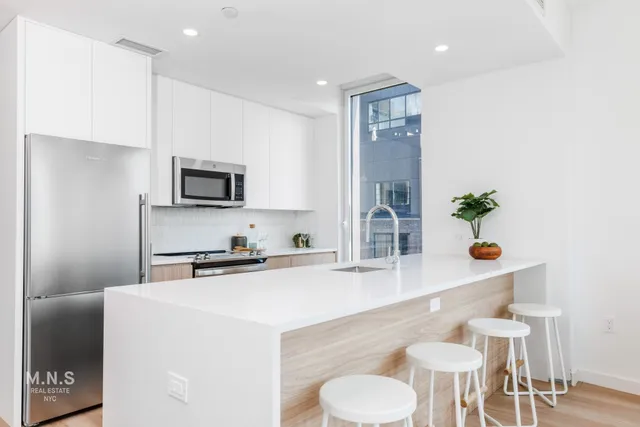 a kitchen with a sink a stove and chairs