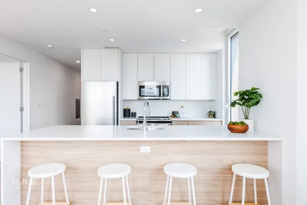 a kitchen with stainless steel appliances granite countertop a sink a stove a refrigerator and cabinets