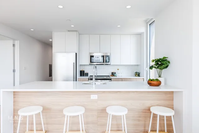 a kitchen with stainless steel appliances granite countertop a sink a stove a refrigerator and cabinets