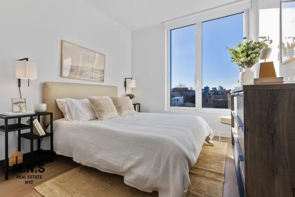 a bedroom with bed and a potted plant