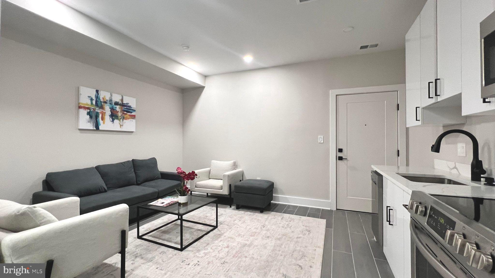 a living room with furniture and a kitchen