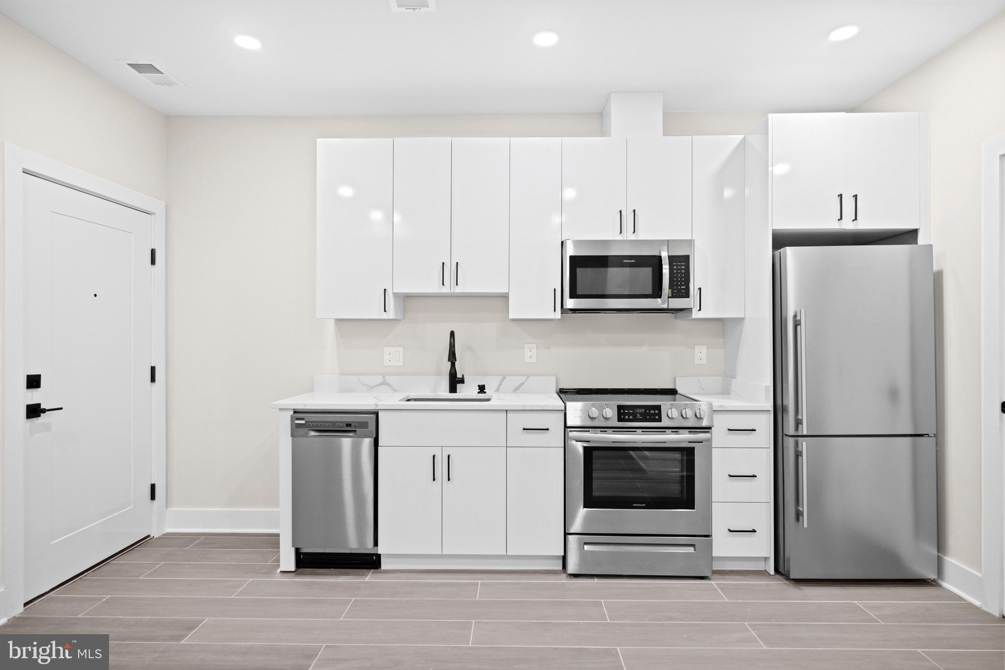 824 18th Street Northeast, Unit 1 Washington, DC 20002 - Photo 6 of 21 a kitchen with a stove a microwave and a refrigerator