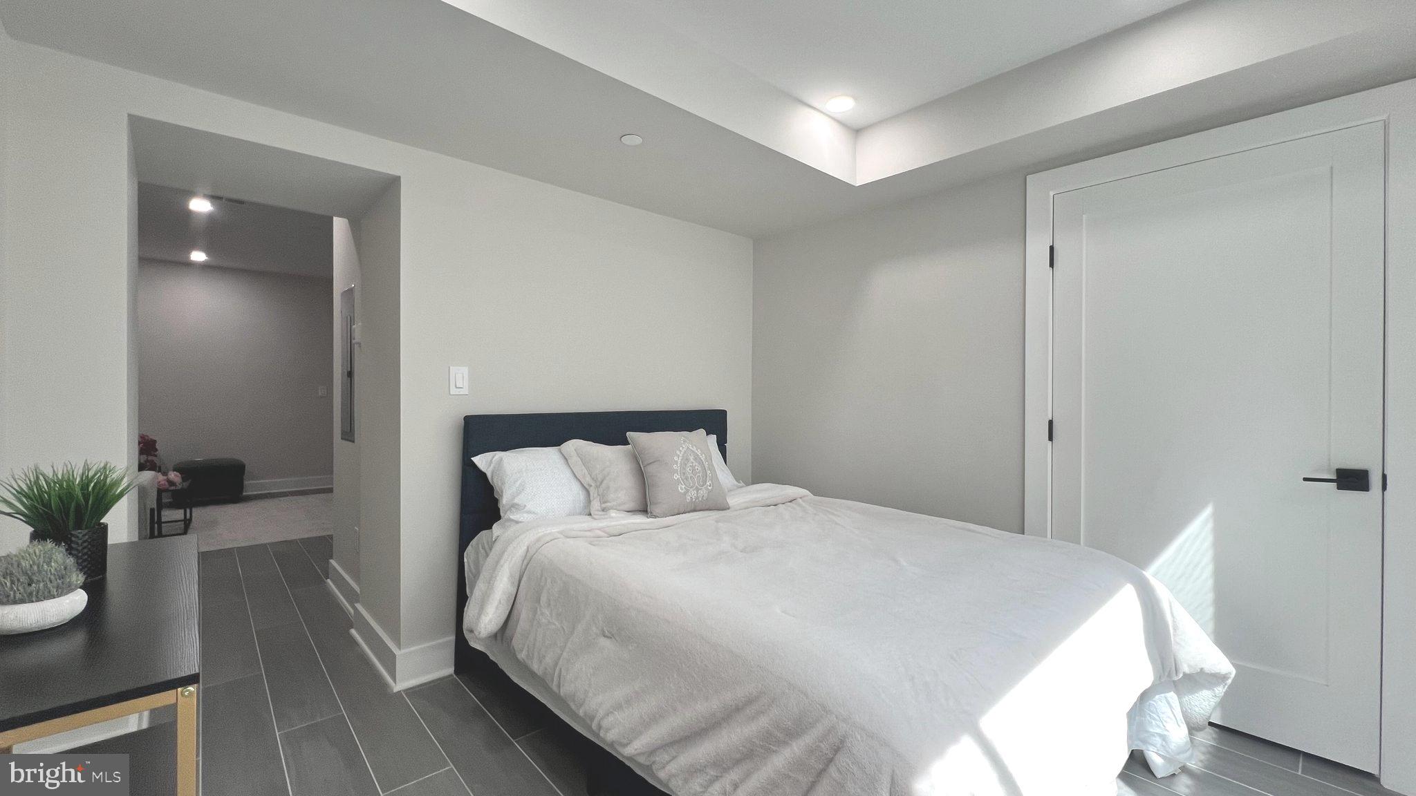 824 18th Street Northeast, Unit 1 Washington, DC 20002 - Photo 9 of 21 a bedroom with a bed and potted plants with wooden floor
