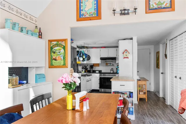 a dining room with stainless steel appliances kitchen island granite countertop a dining table chairs stove and a refrigerator