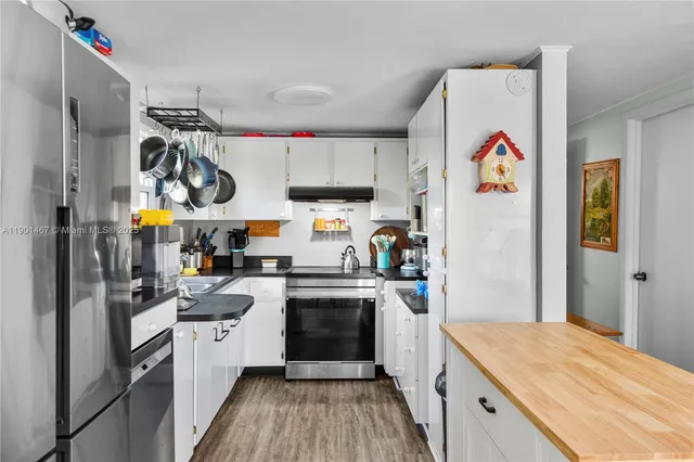 a kitchen with a refrigerator a stove and wooden floor