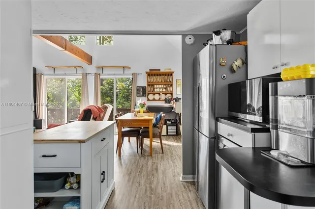 a kitchen with a table chairs refrigerator and a window