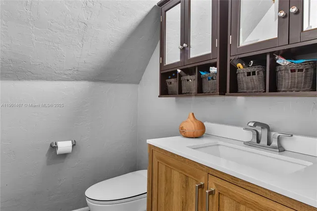 a bathroom with a toilet a sink and mirror