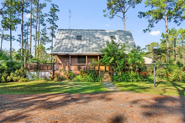 a view of a house with a yard and potted plants
