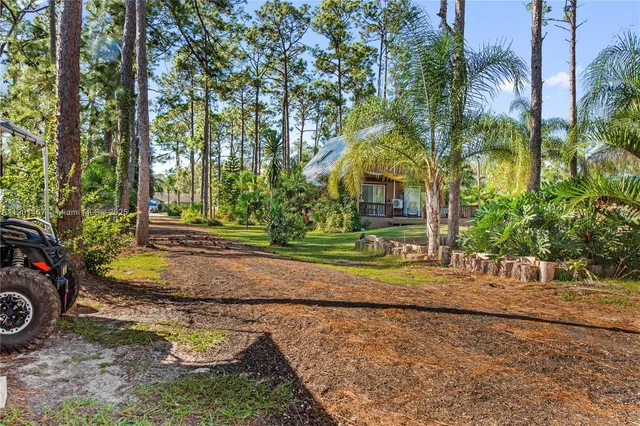 a view of a house with car parked next to a road