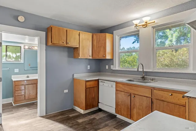 a kitchen with a sink window and cabinets